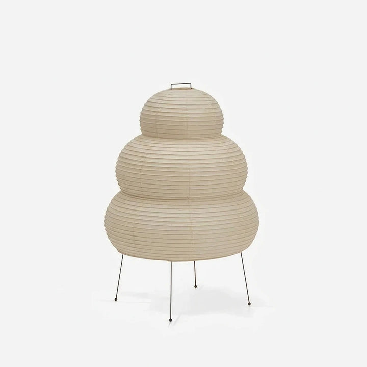 Tiered stacked mulberry paper table lamp with a tripod base on a soft grey background
