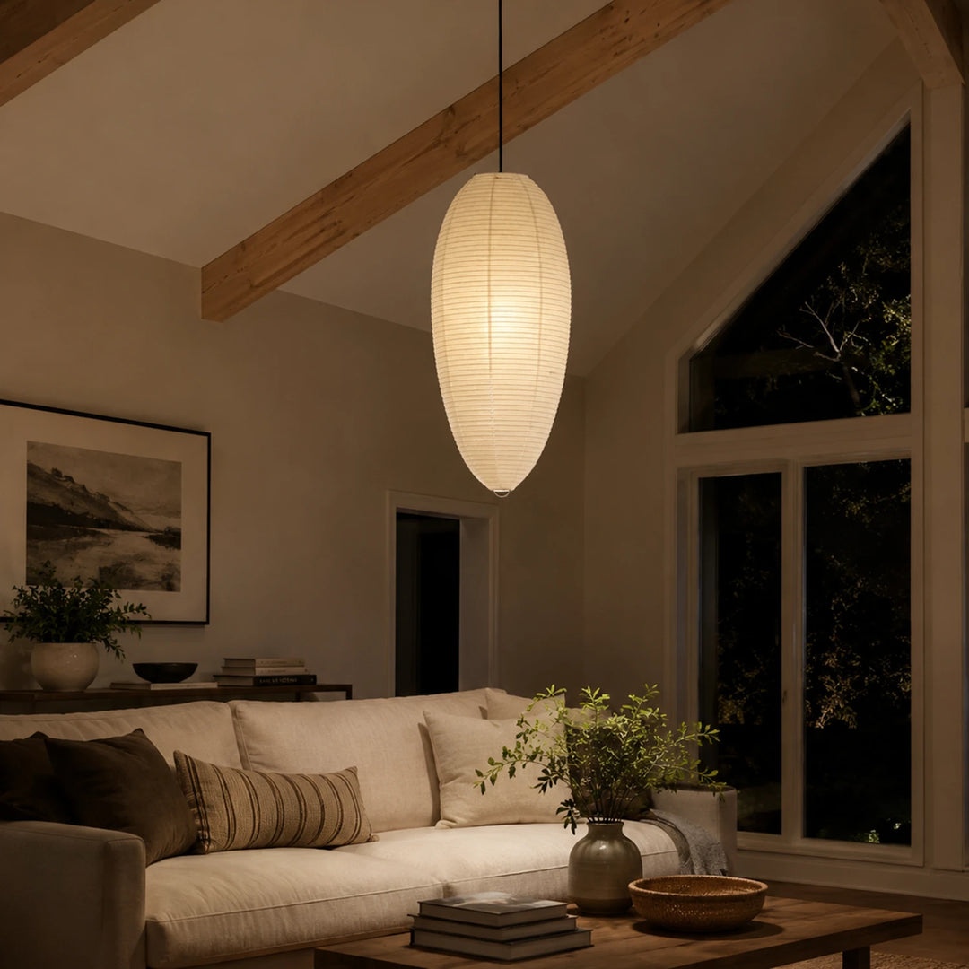 Oval paper pendant under a vaulted ceiling beside a dark night window
