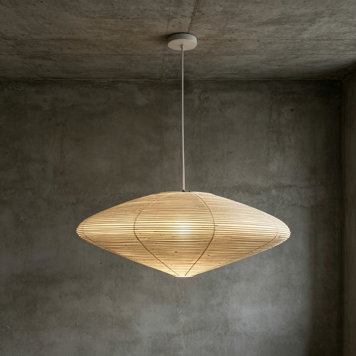 Diamond shaped oval washi paper pendant light with white cord against concrete texture wall