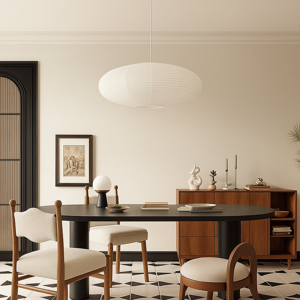 Oval washi paper pendant light above black oval dining table in modern neutral dining room