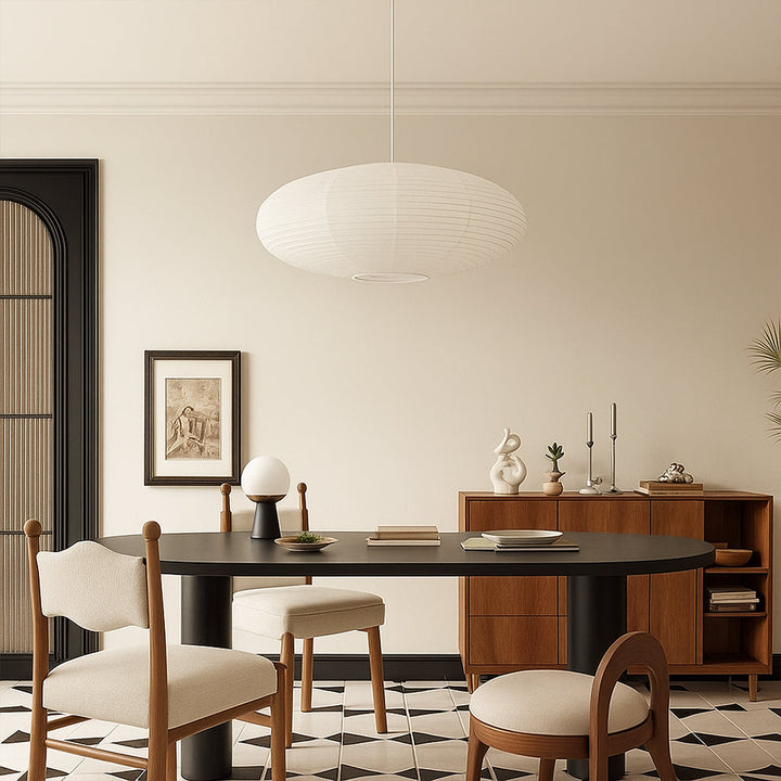 Oval washi paper pendant light above black oval dining table in modern neutral dining room