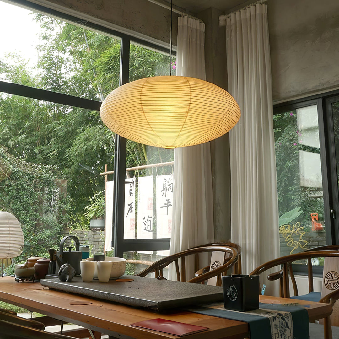 Washi paper oval pendant lamp above solid wood tea table inside oriental style tea room
