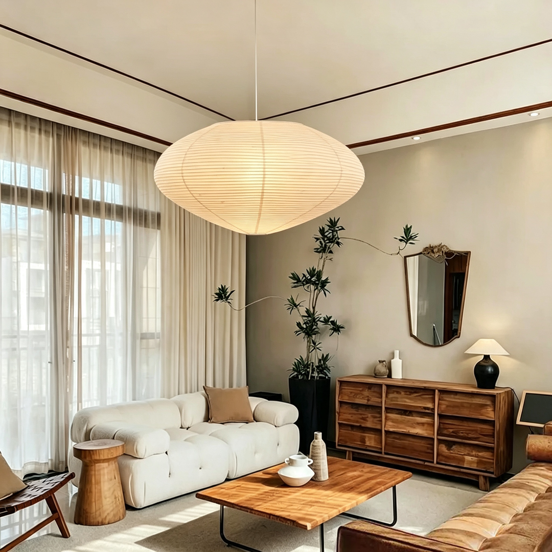 Washi paper oval pendant light hanging in wabi-sabi living room with white bubble sofa and sheer window curtains