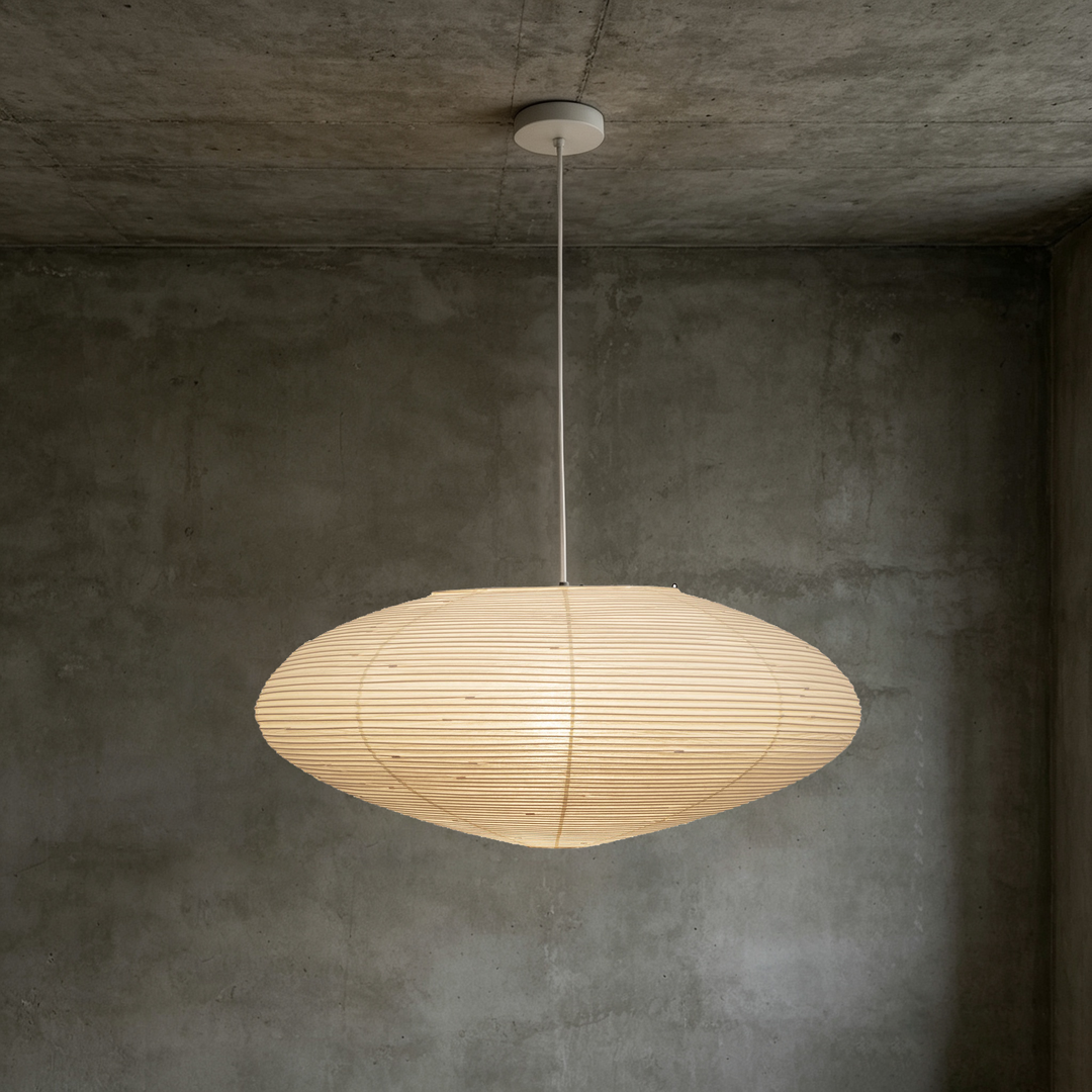 Washi paper oval pendant light with white thin suspension cord on matte concrete interior wall