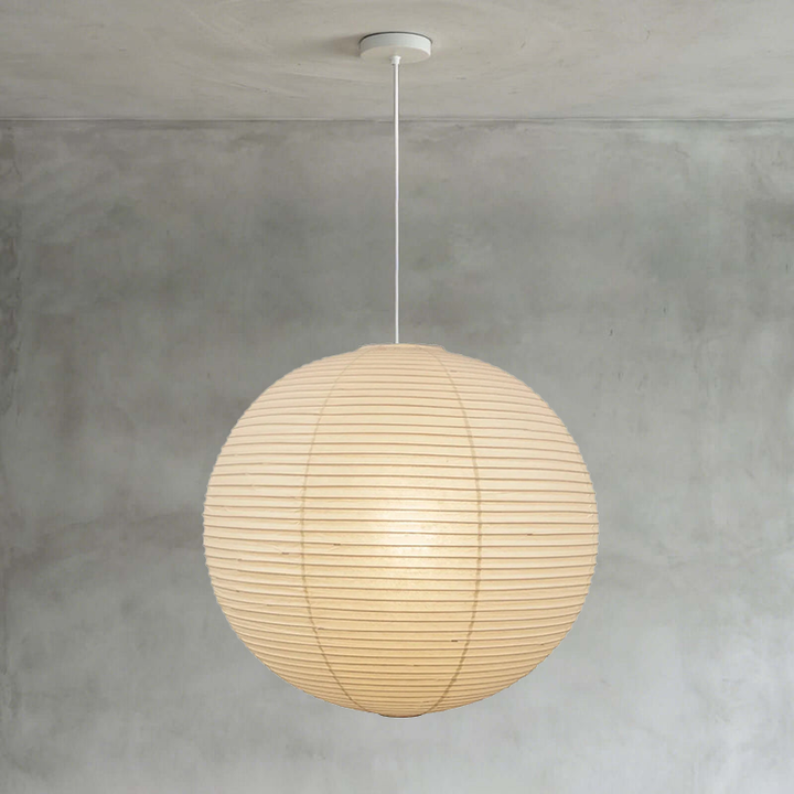 Mini spherical washi paper lamp with thin white cord on smooth grey wall background