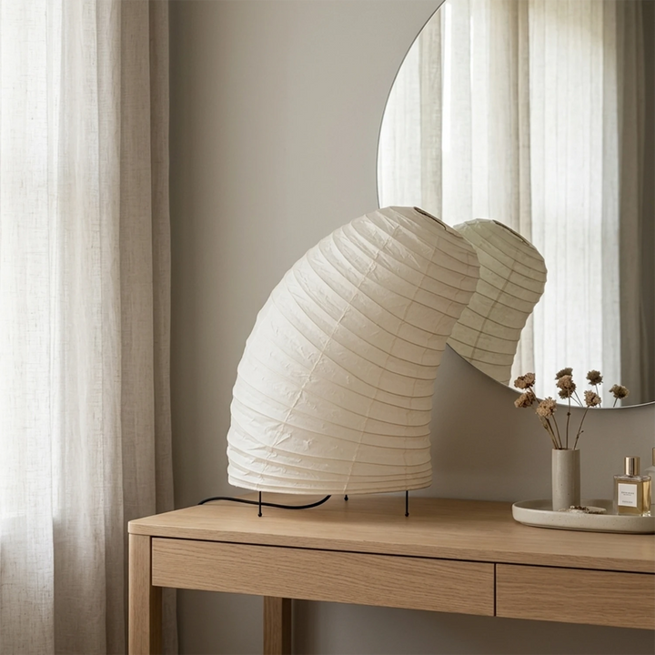 Sculptural paper lamp on a table by a window at golden-hour sunset
